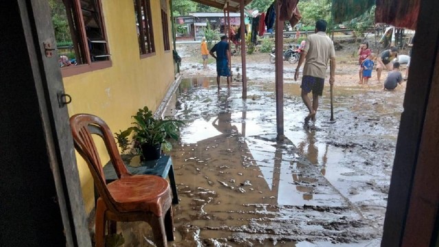 Warga sedang membersihkan rumah mereka yang dipenuhi lumpur akibar banjir yang merendam rumah mereka. Foto: Istimewa.