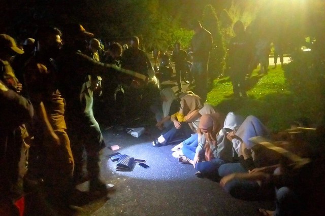 Petugas gabungan mengamankan 11 perempuan beserta botol bekas minuman keras (miras) di kawasan wisata Ulee Lheue, Kota Banda Aceh, Minggu (16/10) dini hari. Foto: Dok. Polisi