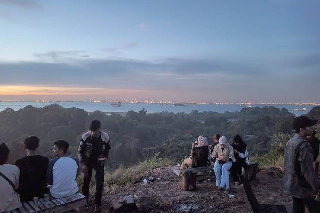 Anak-anak muda Batam bersantai di puncak Bukit Harimau sambil menikmati pamandangan Singapura (Foto: Arjuna/Batamnews)