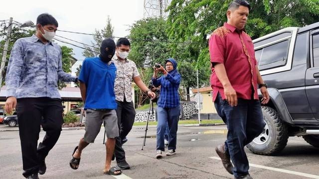 RA (kedua dari kiri), pelaku pembakaran bendera merah putih saat dibawa ke Mapolda Aceh usai ditangkap di Bireuen beberapa waktu lalu. Foto: Habil Razali/acehkini
