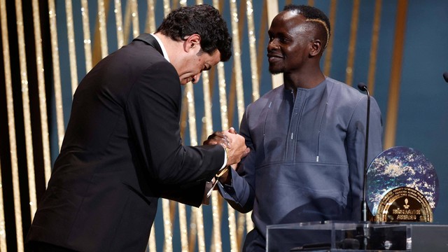 Mantan pemain Socrates Rai memberikan Penghargaan Socrates kepada Pemain Bayern Muenchen Sadio Mane saat Ballon d'Or 2022 di Teater Chatelet, Paris, Prancis Senin (17/10/2022). Foto: Benoit Tessier/Reuters