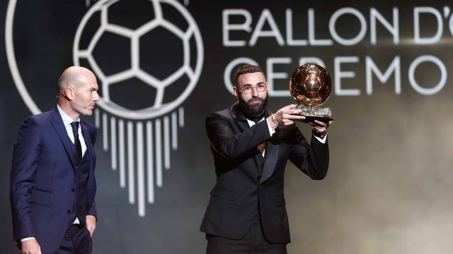 Pemain Real Madrid Karim Benzema menerima trofi Ballon d'Or dari mantan pemain dan manajer Zinedine Zidane di Teater Chatelet, Paris, Prancis Senin (17/10/2022). Foto: Benoit Tessier/Reuters