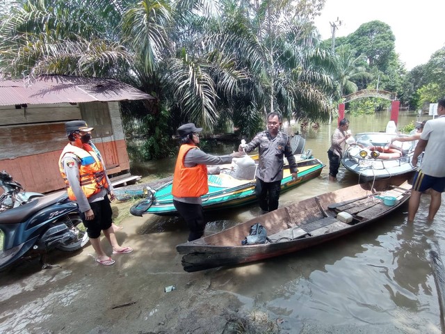 IST/BERITA SAMPIT - Anggota Polres Lamandau saat membagikan paket sembako di lokasi banjir di Desa Sungai Mentawa.