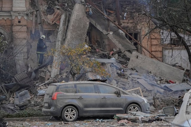 Seorang petugas pemadam kebakaran bekerja di sebuah bangunan tempat tinggal yang dihancurkan oleh serangan pesawat tak berawak Rusia, di Kiev, Ukraina, Senin (17/10/2022). Foto: Roman Petushkov/REUTERS
