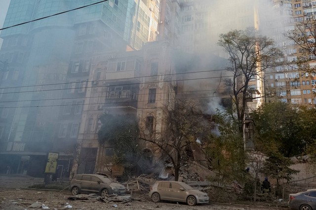 Seorang petugas pemadam kebakaran bekerja di sebuah bangunan tempat tinggal yang dihancurkan oleh serangan pesawat tak berawak Rusia, di Kiev, Ukraina, Senin (17/10/2022). Foto: Roman Petushkov/REUTERS