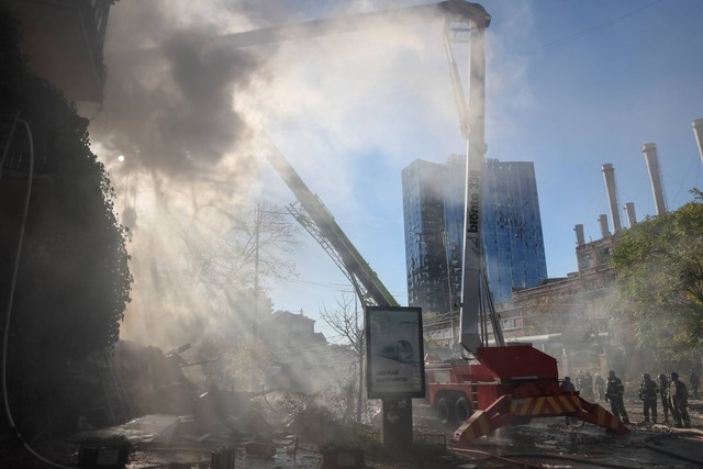 Petugas pemadam kebakaran memadamkan api di sebuah bangunan tempat tinggal yang dihancurkan oleh serangan pesawat tak berawak Rusia, di Kiev, Ukraina, Senin (17/10/2022). Foto: Gleb Garanich/REUTERS