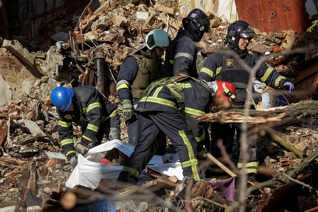Tim penyelamat mengeluarkan mayat dari sebuah bangunan tempat tinggal yang dihancurkan oleh serangan pesawat tak berawak Rusia, di Kiev, Ukraina, Senin (17/10/2022). Foto: Vadim Sarakhan/REUTERS
