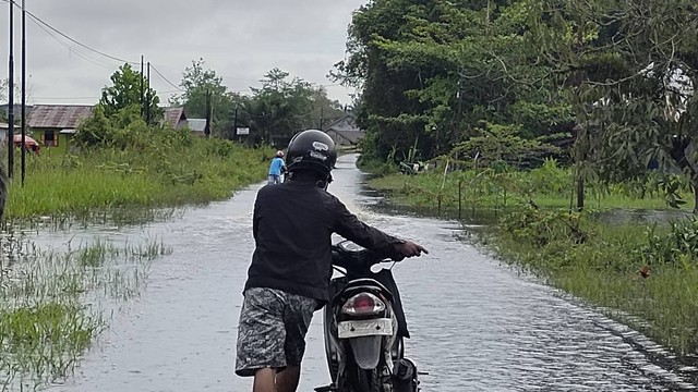 Warga terpaksa harus mendorong motornya melewati genangan banjir sepanjang kurang lebih 350 meter di Jalan Jenderal Sudirman Rt 24 Kelurahan Mendawai, Kotawaringin Barat. Foto: Lukman Hakim/InfoPBUN