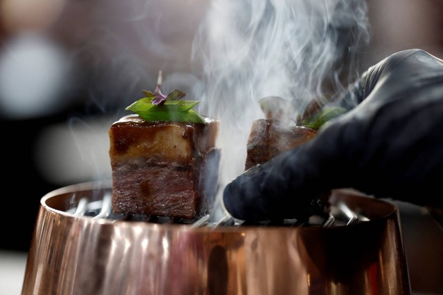 Seorang koki mengatur hidangan yang berisi daging vegan nabati yang dicetak 3D, diproduksi oleh Redefine Meat, dipajang di pameran makanan dan inovasi SIAL di Villepinte, dekat Paris, Prancis, Rabu (19/10/2022). Foto: Benoit Tessier/REUTERS
