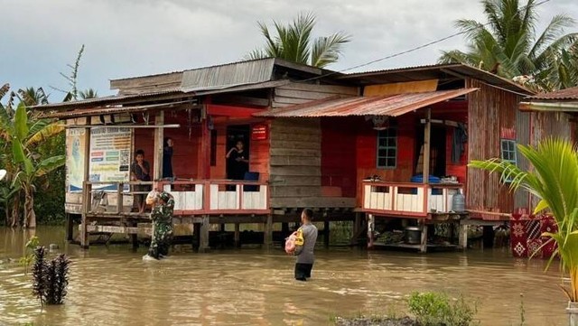 Personel Polres Mamuju Tengah menyalurkan bantuan ke warga terdampak banjir. Foto: Dokumentasi Polres Mamuju Tengah