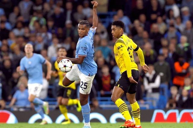 Pemain Manchester City Manuel Akanji berebut bola dengan pemain Borussia Dortmund Jude Bellingham pada pertandingan Grup G Liga Champions di Stadion Etihad, Manchester, Inggris. Foto: Jason Cairnduff/REUTERS