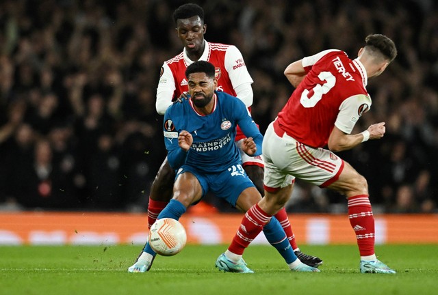 Pemain PSV Eindhoven Philip Mwene duel dengan Eddie Nketiah dan Kieran Tierney dari Arsenal saat pertandingan Liga Europa di Stadion Emirates, London, Inggris. Foto: Dylan Martinez/Reuters 