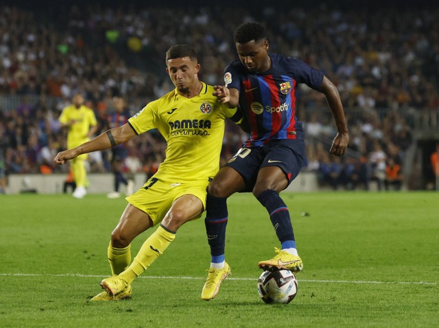 Ansu Fati dari FC Barcelona duel dengan Yeremi Pino dari Villarreal saat pertandingan di Camp Nou, Barcelona, Spanyol. Foto: Albert Gea/Reuters