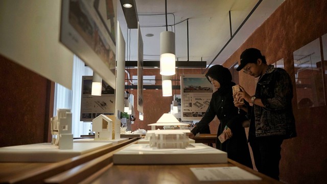 Dua orang pengunjung yang tengah melihat sejumlah produk pada pameran karya arsitektur muda Palembang bertajuk linimasa, Jumat (21/10) Foto: abp/Urban Id