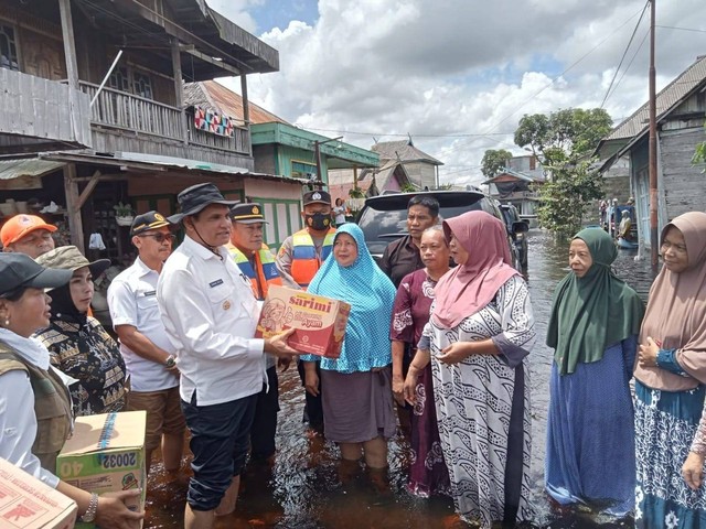 Pj. Bupati Kobar, Anang Dirjo saat memberikan bantuan bansos ke warga yang terdampak banjir. Foto: Prokom