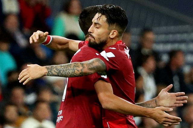 Pemain Sevilla Erik Lamela merayakan gol pertamanya bersama Alex Telles saat hadapi Real Madrid di Santiago Bernabeu, Madrid, Spanyol, Sabtu (22/10/2022). Foto: Violeta Santos Moura/REUTERS