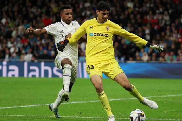 Pemain Real Madrid Rodrygo beraksi bersama kiper Sevilla Bono di Santiago Bernabeu, Madrid, Spanyol, Sabtu (22/10/2022). Foto: Violeta Santos Moura/REUTERS