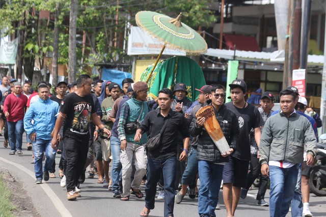 Warga dan suporter tim Arema FC (Aremania) menggotong jenazah Farzah Dwi Kurniawan untuk dimakamkan di Tempat Pemakaman Umum (TPU) Sudimoro, Malang, Jawa Timur, Senin (24/10/2022). Foto: Ari Bowo Sucipto/Antara Foto