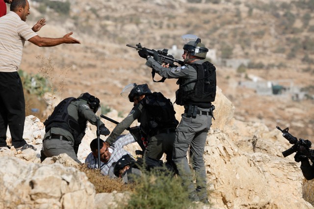 Warga Palestina terlibat bentrok dengan pasukan Israel di Hebron, Tepi Barat yang diduduki Israel, Selasa (25/10/2022). Foto: Mussa Qawasma/Reuters