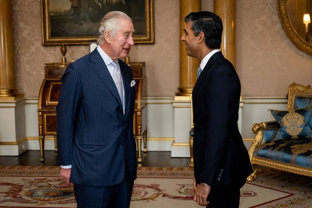 Raja Charles III menyambut Rishi Sunak selama audiensi di Istana Buckingham, London, Selasa (25/10/2022). Foto: Aaron Chown/Pool via REUTERS