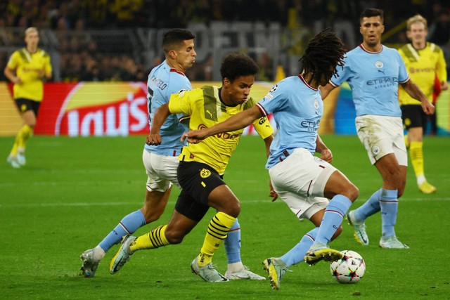 Pemain Manchester City Joao Cancelo dan Nathan Ake berebut bola dengan pemain Borussia Dortmund Karim Adeyemi pada pertandingan Grup G Liga Champions di Signal Iduna Park, Dortmund, Jerman. Foto: Wolfgang Rattay/REUTERS