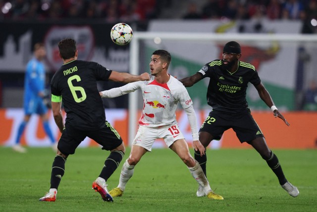 Pemain RB Leipzig Christopher Andre Silva berebut bola dengan pemain Real Madrid Nacho pada pertandingan Grup F Liga Champions di Red Bull Arena, Leipzig, Jerman. Foto: Ronny HARTMANN / AFP