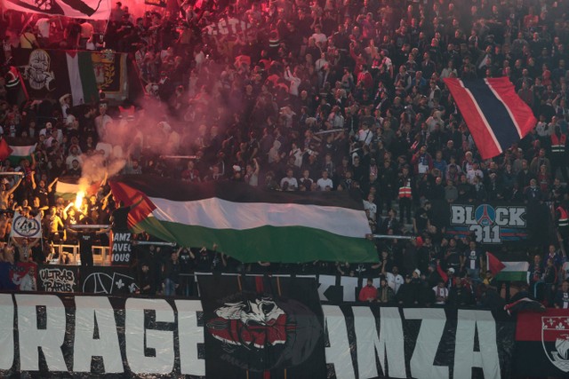 Suporter Paris Saint-Germain membentangkan bendera Palestina dalam pertandingan sepak bola leg ke-2 Grup H Liga Champions UEFA antara PSG dan Maccabi Haifa FC di stadion Parc des Princes di Paris, Prancis, Selasa (25/10/2022). Foto: Geoffroy VAN DER HASSELT / AFP