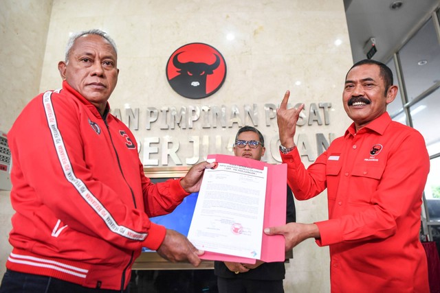 Ketua DPP bidang Kehormatan Komarudin Watubun (kiri) memberikan surat sanksi kepada Ketua DPC PDIP Kota Solo, FX Hadi Rudyanto (kanan) usai pertemuan di Kantor DPP PDI Perjuangan, Jakarta, Rabu (26/10/2022). Foto: M Risyal Hidayat/ANTARA FOTO