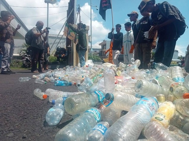 Mahasiswa saat aksi menghamburkan sampah botol plastik di depan kantor Wali Kota Ternate. Sampah tersebut diangkut dari perairan Ternate. Foto: Indrasani Ilham/cermat