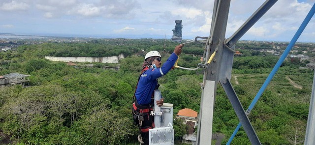 Teknisi XL Axiata memeriksa perangkat BTS di atas tower yang berada di area Nusa Dua, Bali. Foto: XL Axiata