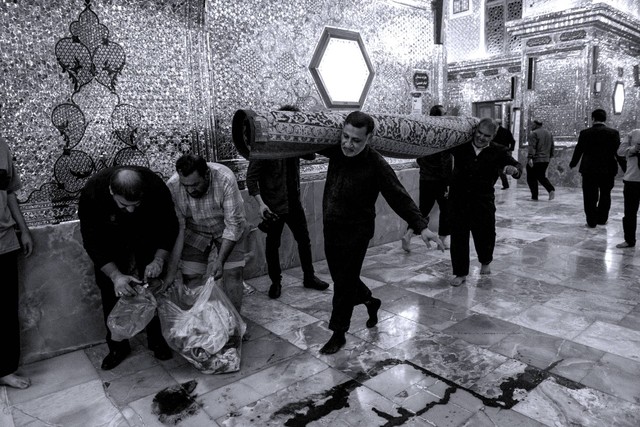 Orang-orang membersihkan darah yang berceceran setelah serangan di Masjid Syiah, di Shah Cheragh, Shiraz, Iran, Rabu (26/10/2022). Foto: Amin Berenjkar/WANA via Reuters