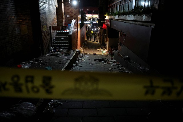 Petugas polisi berjalan di tempat kejadian di mana banyak orang tewas dan terluka karena terinjak-injak saat festival Halloween di Itaewon, Seoul, Korea Selatan, Minggu (30/10/2022). Foto: Kim Hong-Ji/REUTERS