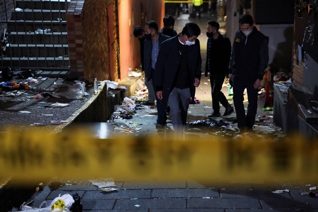 Penyelidik memeriksa tempat kejadian di mana banyak orang tewas dan terluka karena terinjak-injak saat festival Halloween di Itaewon, Seoul, Korea Selatan, Minggu (30/10/2022). Foto: Kim Hong-Ji/REUTERS