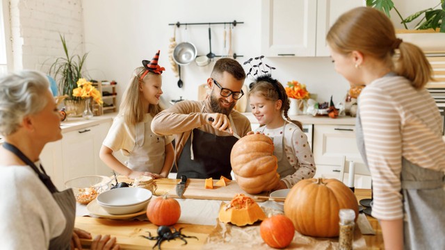 Ilustrasi keluarga yang tengah membuat ukiran labu untuk perayaan Halloween. Foto: Evgeny Atamanenko/Shutterstock