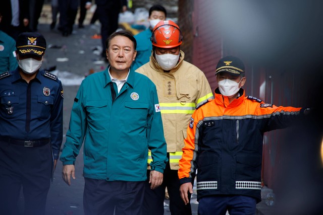 Presiden Korea Selatan Yoon Suk-yeol berjalan di lokasi yang mana banyak orang tewas dan terluka karena terinjak saat festival Halloween di Seoul, Korea Selatan, Minggu (30/10/2022). Foto: Heo Ran/REUTERS
