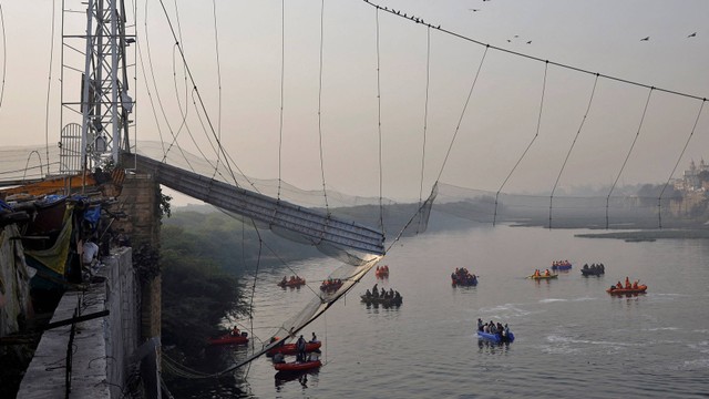 Tim penyelamat mencari korban setelah jembatan gantung runtuh di kota Morbi di negara bagian barat Gujarat, India, 31 Oktober 2022. Foto: REUTERS/Stringer