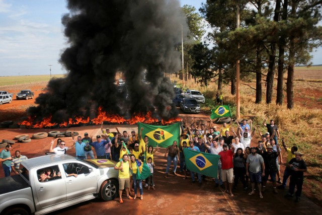 Pendukung Presiden Brasil Jair Bolsonaro memblokir jalan raya BR-251 dengan membakar ban di Planaltina, Brasil, Selasa (31/10/2022). Foto: Diego Vara/Reuters