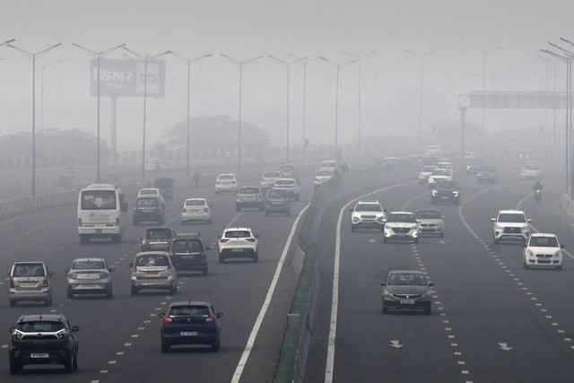Orang-orang bepergian di tengah kondisi kabut asap di New Delhi, Selasa (1/11/2022). Foto: Money Sharma/AFP