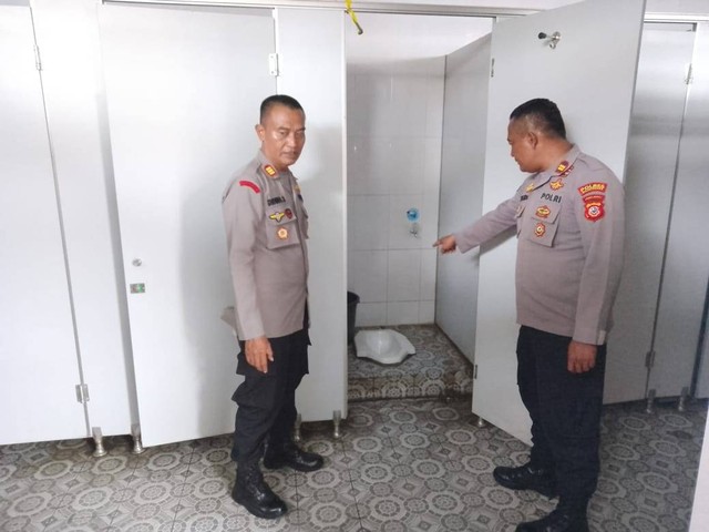 Petugas dari Polres Majalengka menunjukkan lokasi penemuan jasad bayi di toilet pabrik PT Shoetown Ligung Indonesia. Foto: Istimewa