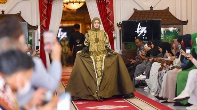 Model memperagakan busana dengan motif Aceh dalam ajang "Afternoon Tea Fashion" pada Minggu (27/3/2022). Foto: Suparta/acehkini