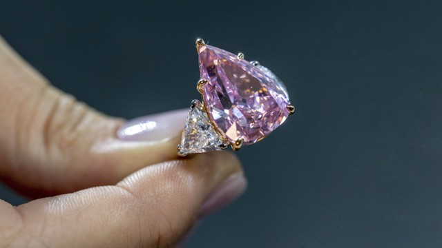 Seorang model menunjukan berlian merah muda 18,18 karat yang disebut "Fortune Pink" yang bisa terjual 30 juta dolar AS selama pratinjau di Christie's sebelum penjualan lelang di Jenewa, Swiss, 2 November 2022. Foto: Denis Balibouse/Reuters