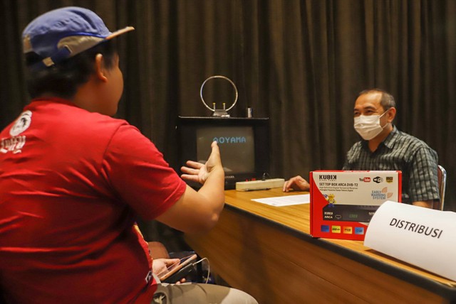 Petugas Kementerian Kominfo (Komunikasi dan Informatika) memberikan penjelasan penggunaan alat STB (Set Top Box) yang dibagikan secara gratis kepada warga di Posko Respon Cepat Penanganan Bantuan STB di Hotel Akmani, Jakarta, Kamis (3/11/2022). Foto: Iqbal Firdaus/kumparan