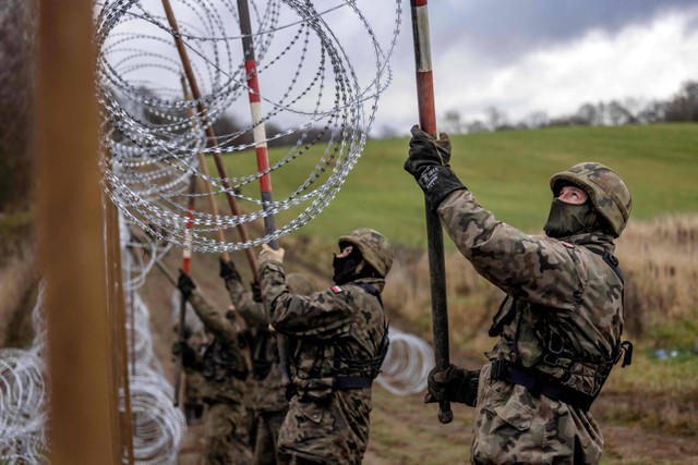 Tentara Polandia membangun pagar kawat berduri di perbatasan Polandia-Rusia di wilayah Oblast Kaliningrad, Zerdziny, Polandia, Kamis, (3/11/2022). Foto: Wojtek Radwanski/AFP