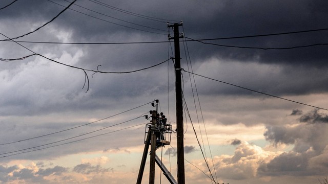 Petugas memperbaiki saluran listrik yang terputus di kota Kupiansk, wilayah Kharkiv, Ukraina pada Kamis (3/11/2022). Foto: Dimitar Dilkoff/AFP