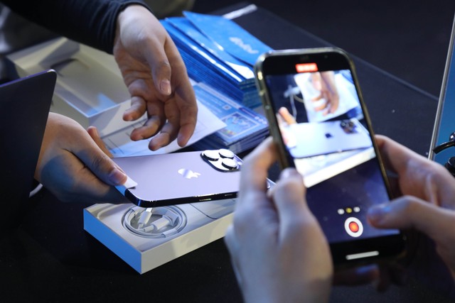 Seorang pembeli merekam secara live pada penjualan iPhone 14 dan iPhone 14 Pro perdana dalam acara Midnight Lounge di Senayan Park Dome, Jakarta, Jumat (4/11).  Foto: Aditia Noviansyah/kumparan