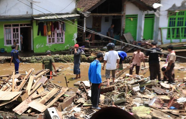 Warga bersama relawan mencari barang-barang yang masih bisa dipakai usai lokasi tersebut tersapu banjir di Kalibaru, Banyuwangi, Jawa Timur, Jumat (4/11/2022). Foto: Budi Candra Setya/ANTARA FOTO