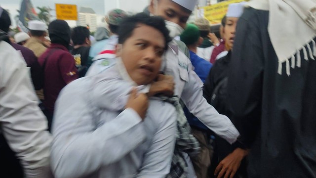 Seorang massa aksi 411 ditarik mundur usai diduga terlibat keributan di Patung Kuda, Jakarta Pusat, Jumat (4/11/2022). Foto: Jonathan Devin/kumparan