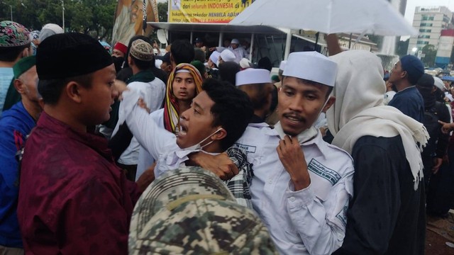 Seorang massa aksi 411 ditarik mundur usai diduga terlibat keributan di Patung Kuda, Jakarta Pusat, Jumat (4/11/2022). Foto: Jonathan Devin/kumparan