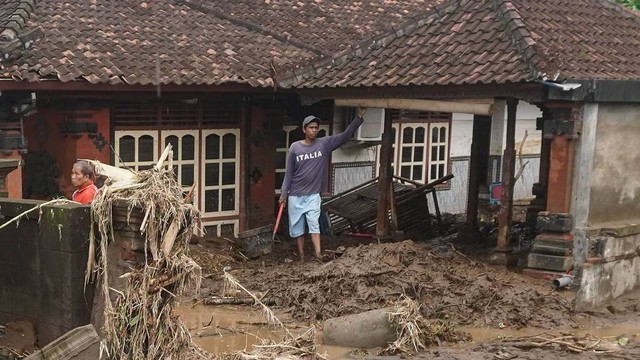 Dua warga mengumpulkan barang-barangnya setelah rumahnya sempat disapu banjir di Desa Tegal Cangkring, Jembrana, Bali, Selasa (18/10/2022). Foto: Dicky Bisinglasi/Antara Foto