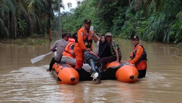 Tim SAR dan polisi mengevakuasi warga yang sakit di Aceh Tamiang menggunakan perahu karet, Jumat (4/11). Foto: Polres Aceh Tamiang